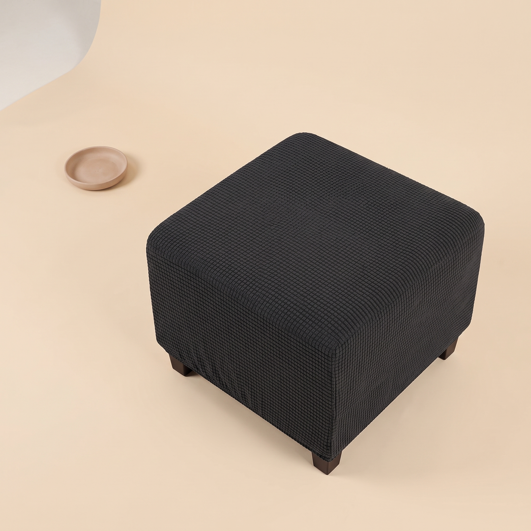 Stretch Ottoman Cover in Dark Gray – high angle view beside a small empty ceramic dish