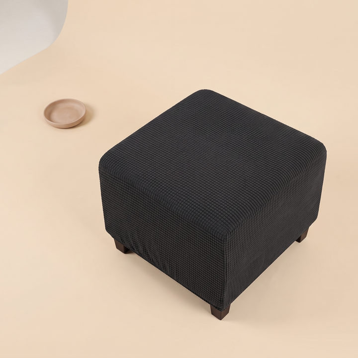 Stretch Ottoman Cover in Dark Gray – high angle view beside a small empty ceramic dish