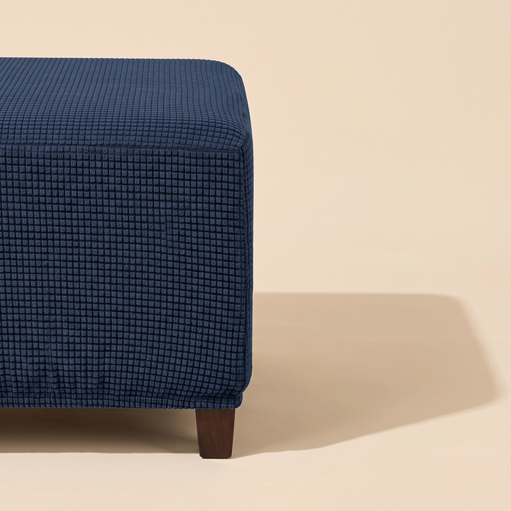 Stretch Ottoman Cover in Navy Blue – cropped at left edge with long angular floor shadow