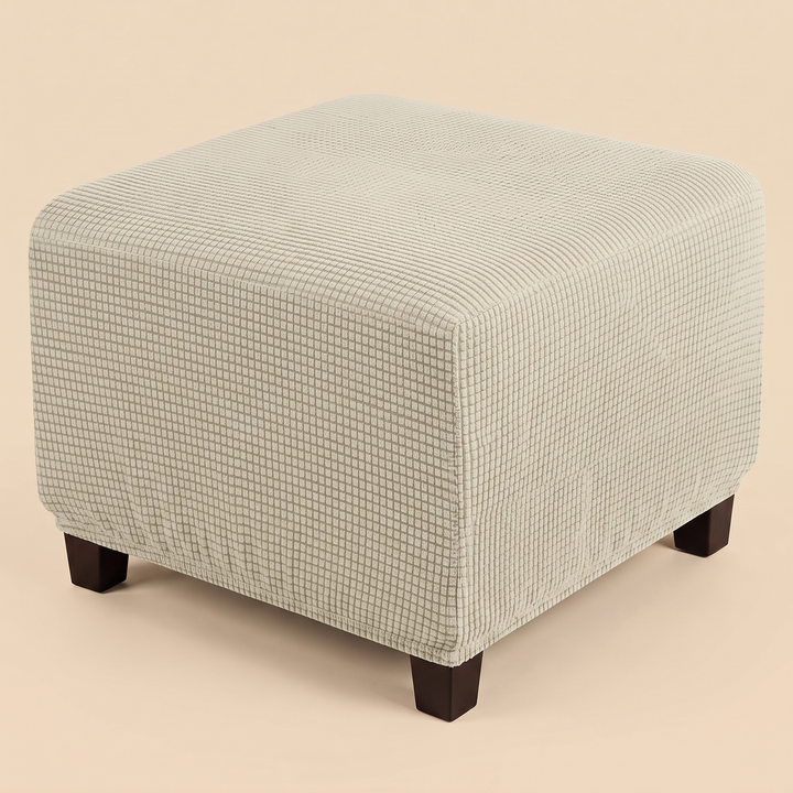 Stretch Ottoman Cover in Oatmeal – raised corner angle showing gathered hem above tapered feet