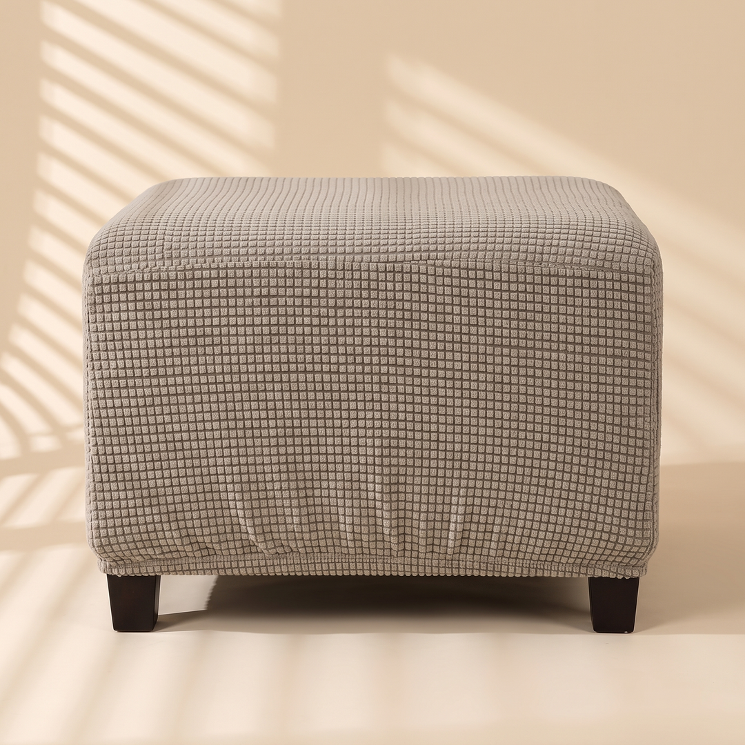 Stretch Ottoman Cover in Taupe – straight-on front view with striped window light shadows across the wall
