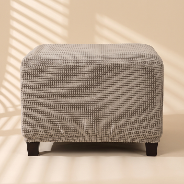 Stretch Ottoman Cover in Taupe – straight-on front view with striped window light shadows across the wall