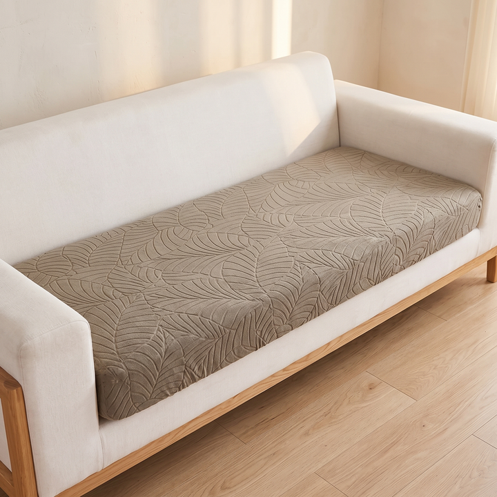 Stretch Couch Cushion Cover – Leaf Jacquard in Beige – fitted over a sofa seat cushion on a wood-frame couch