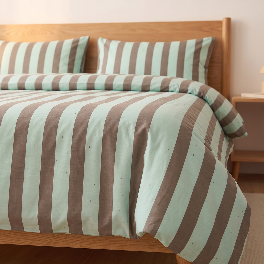 Striped Cotton Duvet Cover Set in Mint Green Stripe – low side angle of duvet draped over wooden bed edge