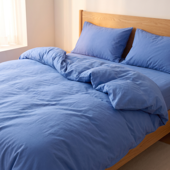 Striped Cotton Duvet Cover Set in Solid Blue – loosely rumpled duvet and two pillows on an unmade bed