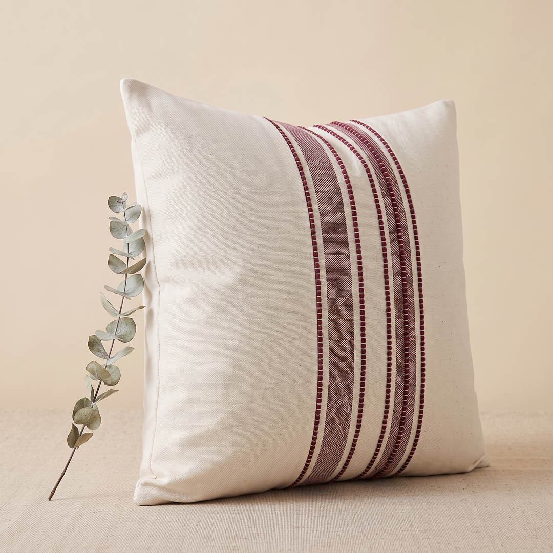 Striped Throw Pillow Cover in Burgundy Stripe – eucalyptus stem leaning against the pillow&