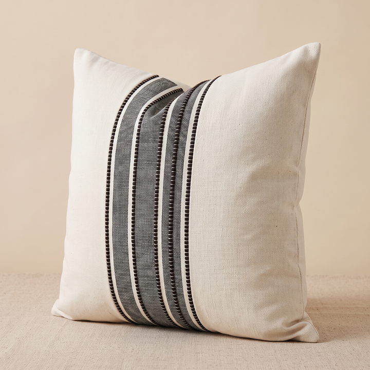 Striped Throw Pillow Cover in Charcoal Stripe – angled three-quarter view resting on a woven textured tabletop