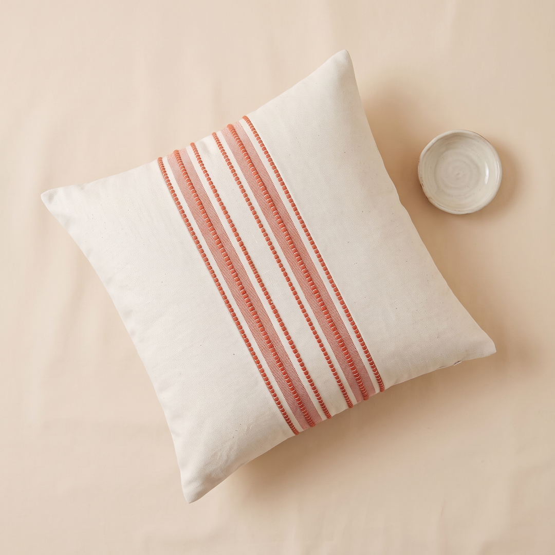 Striped Throw Pillow Cover in Coral Stripe – seen from above beside a small ceramic dish