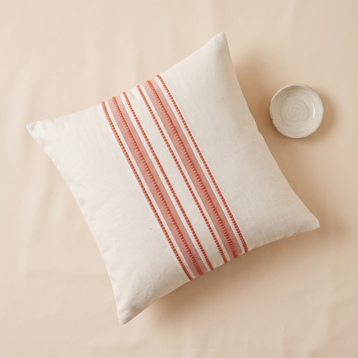 Striped Throw Pillow Cover in Coral Stripe – seen from above beside a small ceramic dish