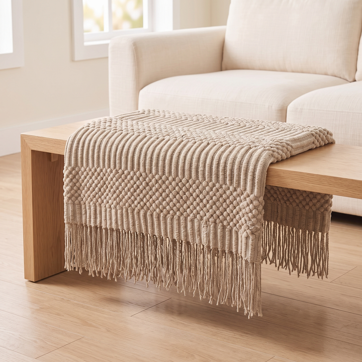 Knit Throw Blanket with Fringe in Beige Bobble – folded across a low oak bench with the fringe hanging at both ends