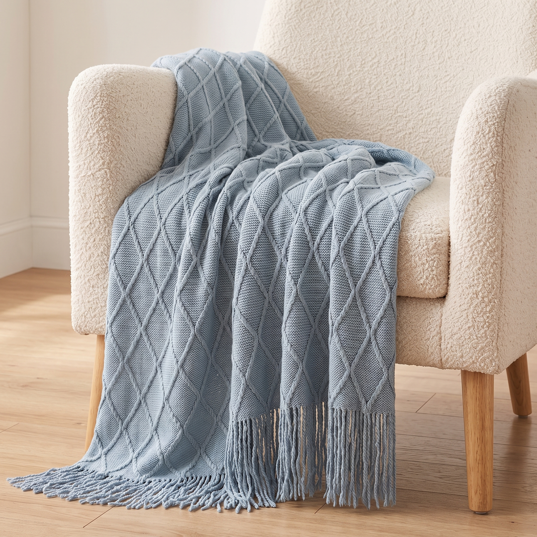 Knit Throw Blanket with Fringe in Light Blue Diamond – cascading over a cream boucle chair, fringe pooling on floor