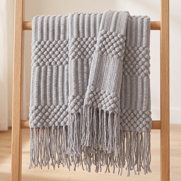 Knit Throw Blanket with Fringe in Light Gray Bobble – hanging folded over a wooden blanket ladder against a white wall