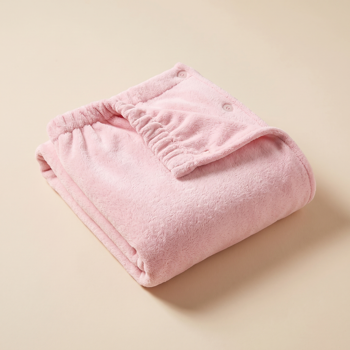 Towel Wrap – Bath &amp; Spa in Pink – folded neatly on a plain beige surface, showing elastic edge and snap buttons