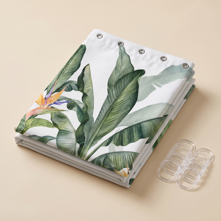 Tropical Shower Curtain – Monstera &amp; Palm Leaves in White – Banana Leaves – folded on a beige surface with clear hooks beside it