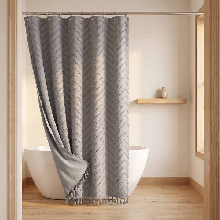 Boho Fabric Shower Curtain – Tufted, with Tassels in Dark Gray Chevron – corner pulled back to show plain reverse, wood shelf behind