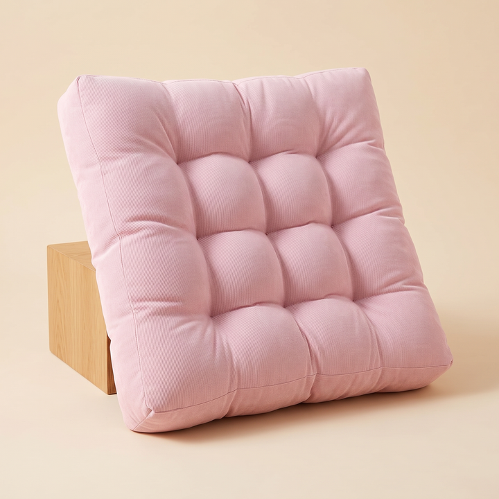 Tufted Floor Cushion – Square in Light Pink – propped upright against a wooden block on beige