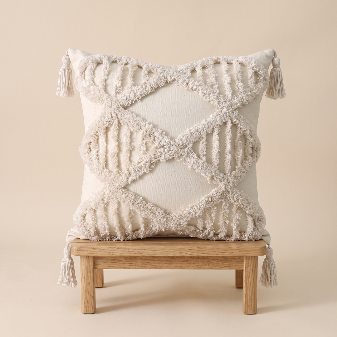 Boho Tufted Pillow Cover with Tassels in Cream – Lattice – propped on a small wooden stool with lower tassels hanging