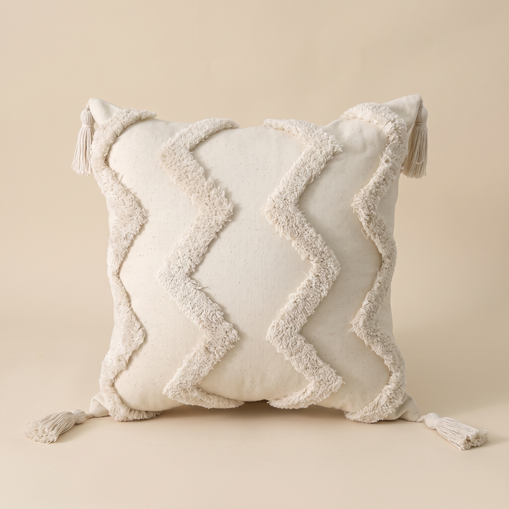 Boho Tufted Pillow Cover with Tassels in Cream – Zigzag – front view standing upright against a plain beige backdrop