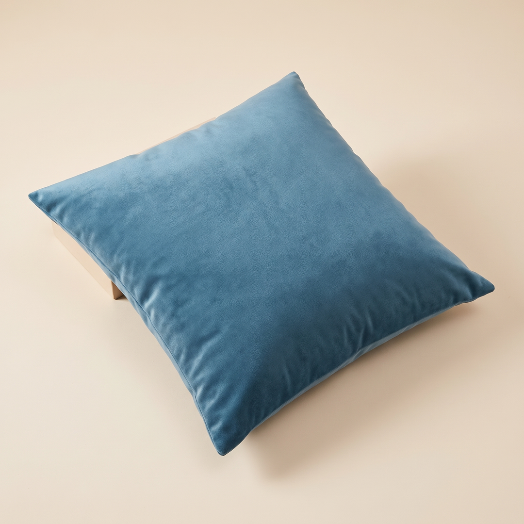 Velvet Pillow Cover in Blue – high-angle view showing soft sheen and gentle creases across the surface