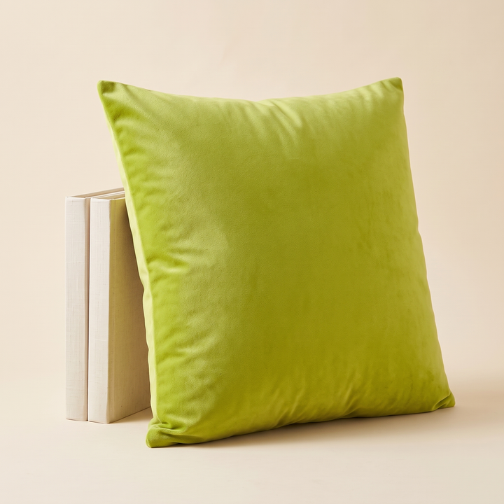 Velvet Pillow Cover in Lime Green – leaning against two upright cream books side by side