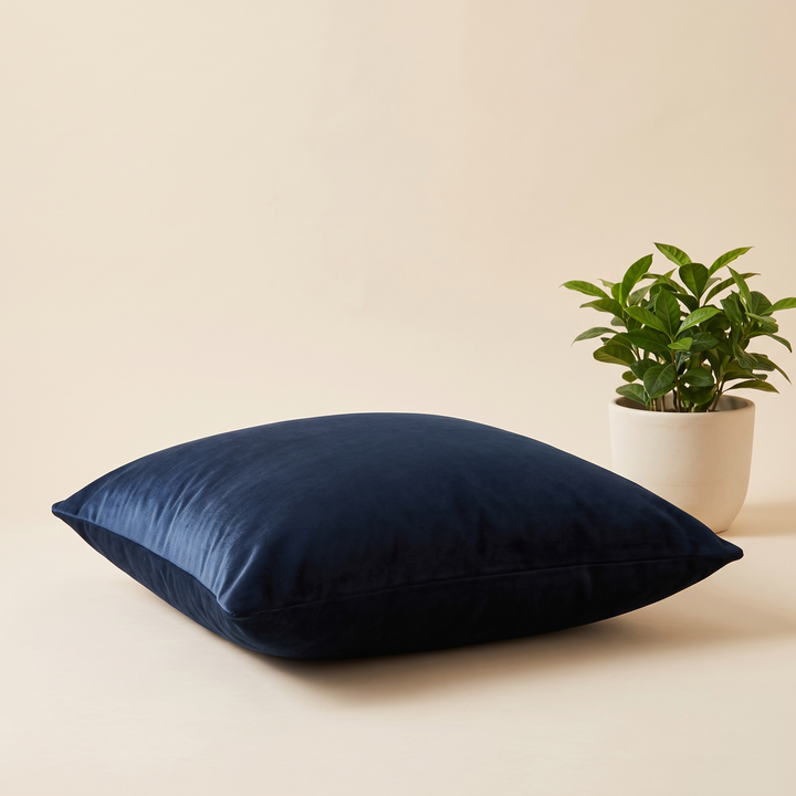 Velvet Pillow Cover in Midnight Blue – lying flat at low angle beside a potted green plant