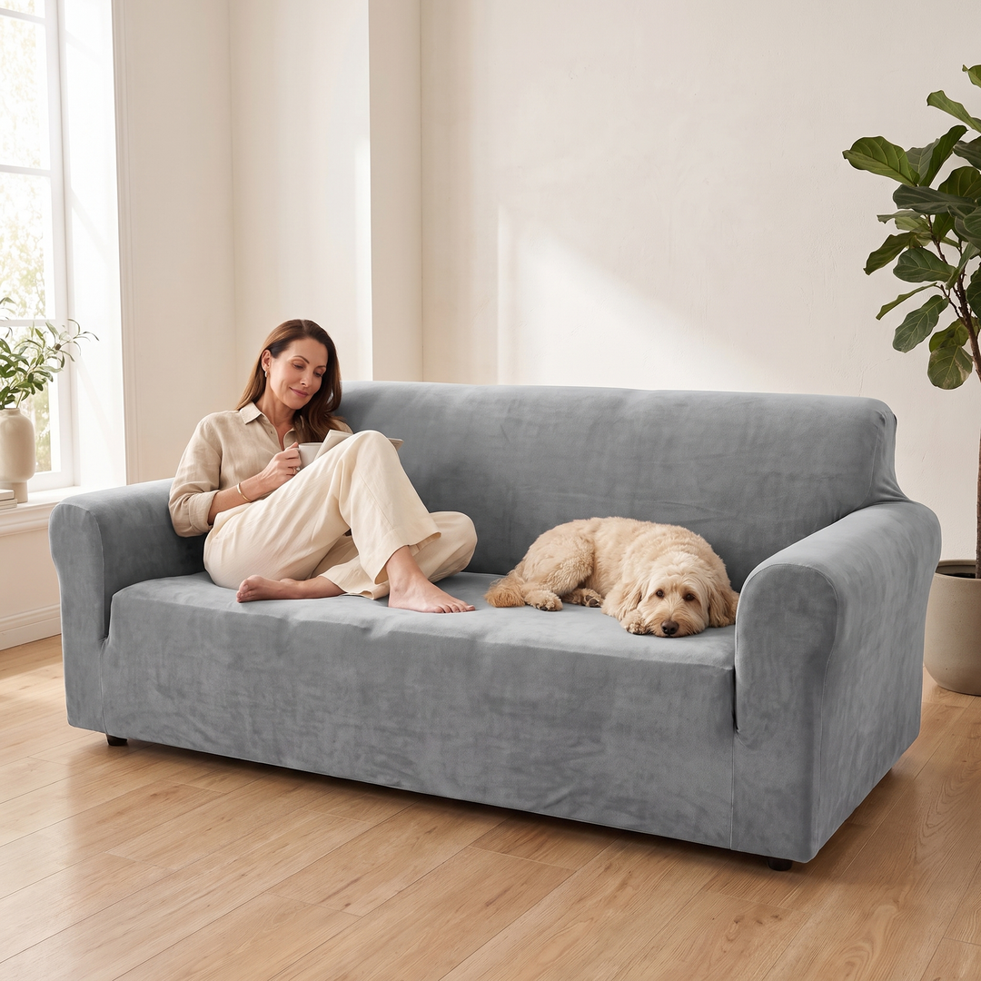 Velvet Stretch Sofa Cover in Gray – with a woman relaxing and a dog lying on it