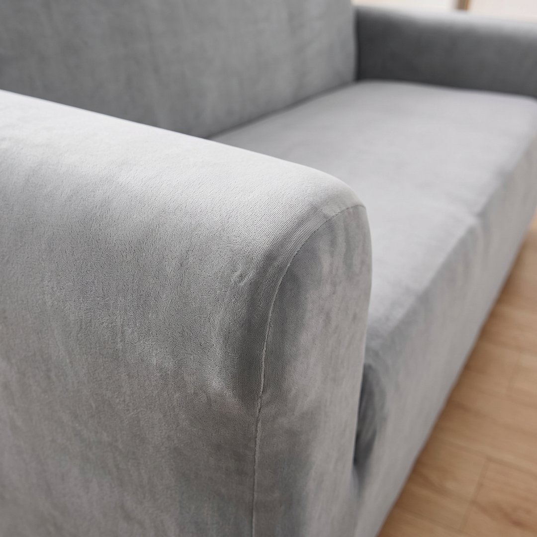 Velvet Stretch Sofa Cover in Gray – close-up of the armrest and seat cushion on wood flooring