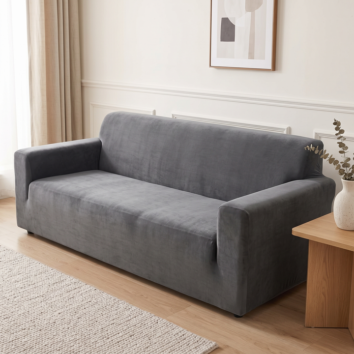 Velvet Stretch Sofa Cover in Dark Gray – against paneled cream wall with beige curtain and woven rug