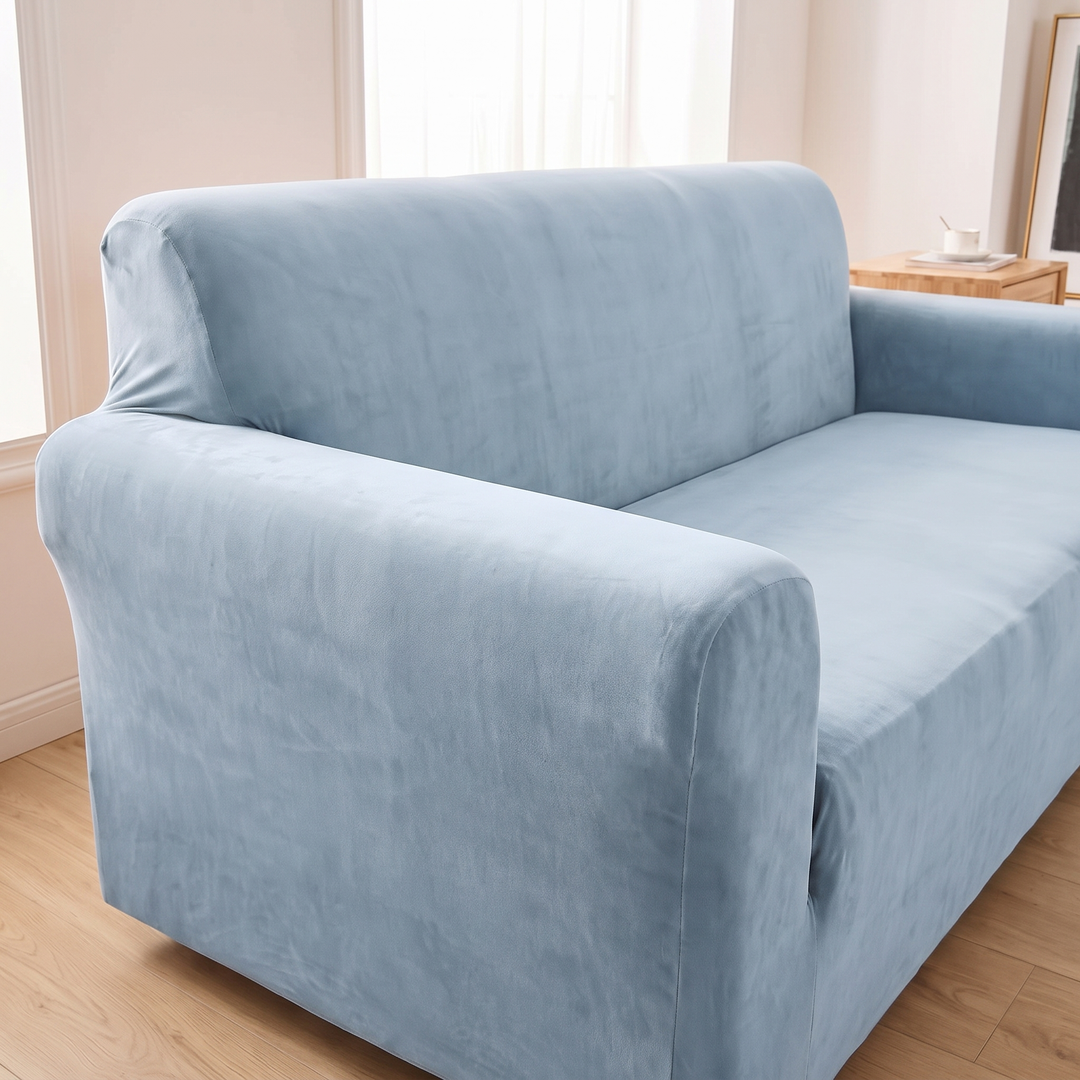 Velvet Stretch Sofa Cover in Dusty Blue – rolled arm and backrest with teacup on table behind