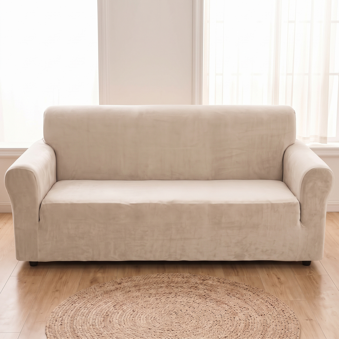 Velvet Stretch Sofa Cover in Oatmeal – straight-on front view with a round jute rug on hardwood floor