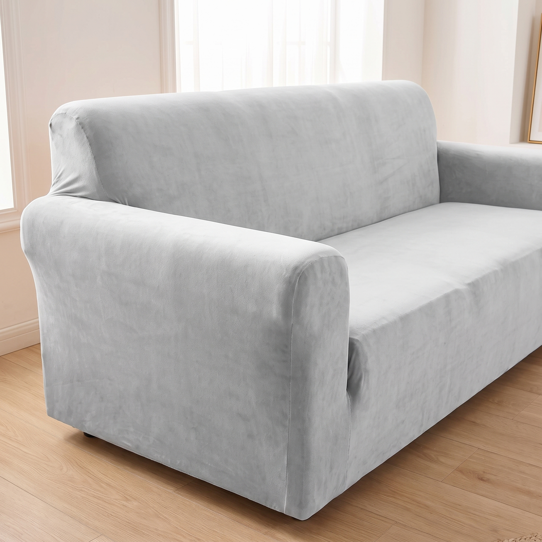 Velvet Stretch Sofa Cover in Silver – three-quarter view of the arm beside a gold frame