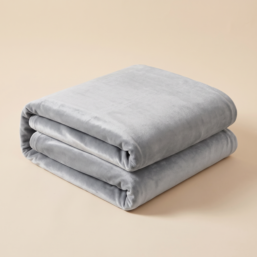 Velvet Stretch Sofa Cover in Gray – folded neatly in a stack on a plain beige background