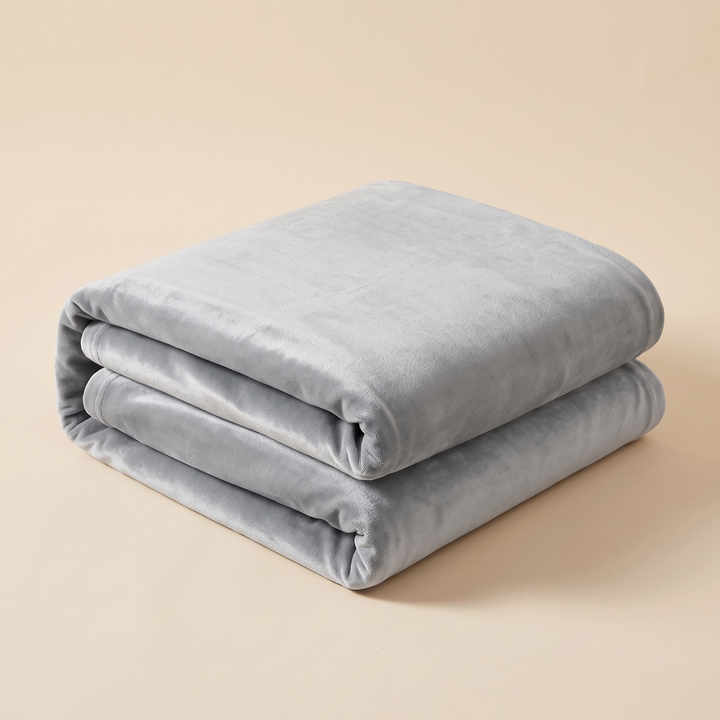 Velvet Stretch Sofa Cover in Gray – folded neatly in a stack on a plain beige background