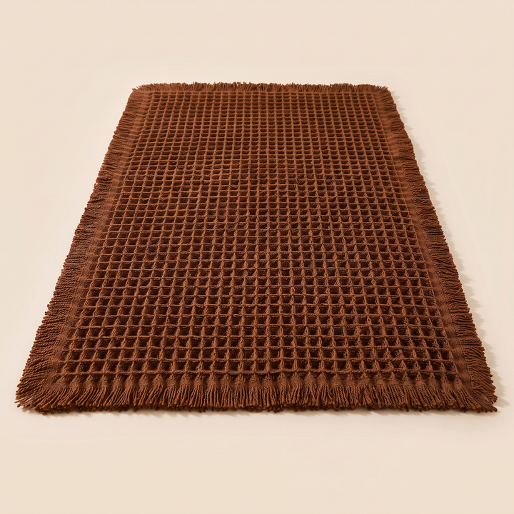 Waffle Bath Mat with Tassels in Chestnut Brown – shot from a low angle, fringe along the near edge