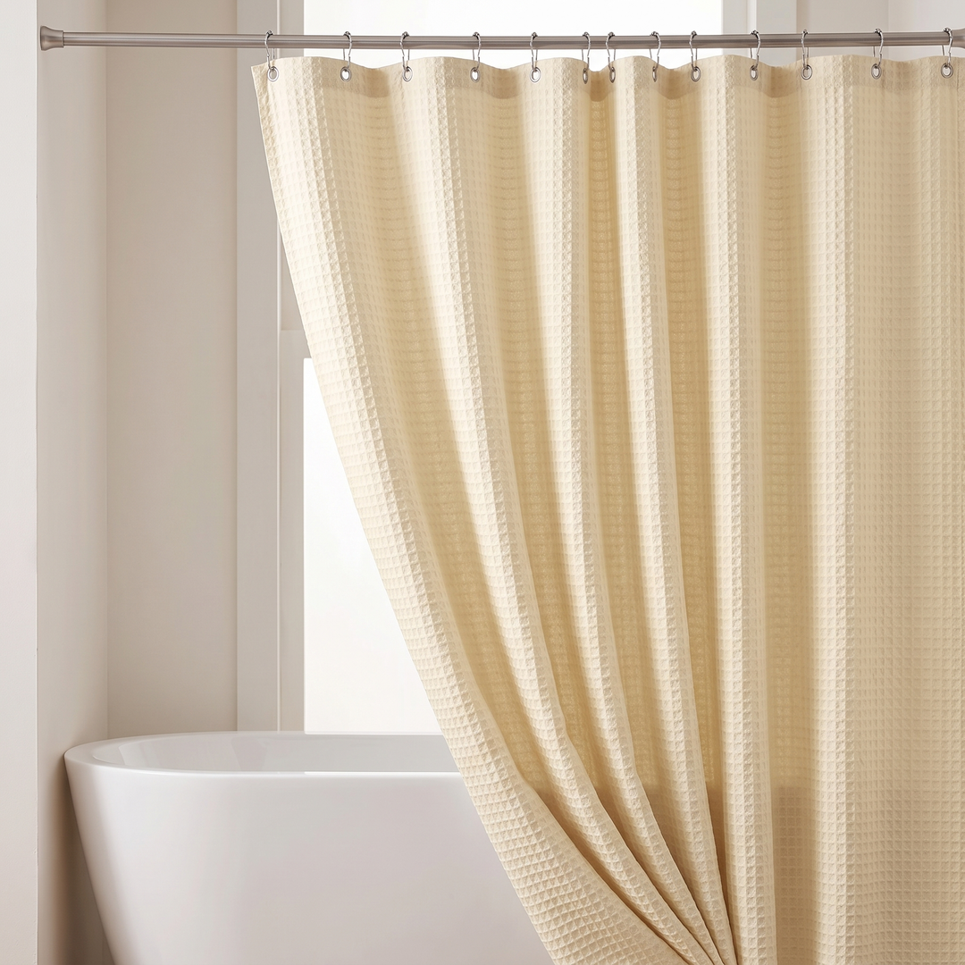 Fabric Shower Curtain – Waffle Weave in Cream – gathered to one side beside a freestanding tub and window