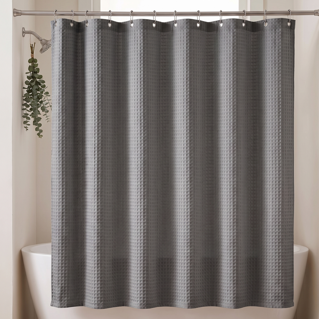 Fabric Shower Curtain – Waffle Weave in Dark Gray – closed beside eucalyptus hanging from the shower arm