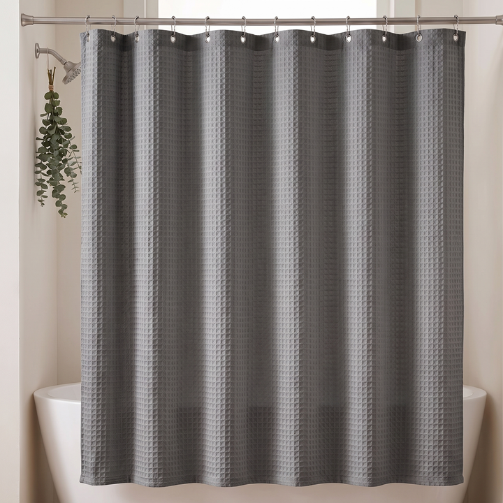 Fabric Shower Curtain – Waffle Weave in Dark Gray – closed beside eucalyptus hanging from the shower arm