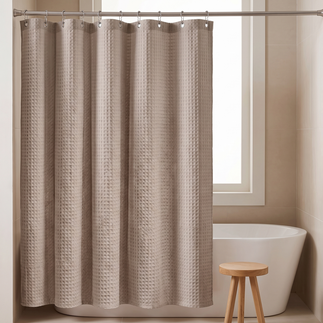 Fabric Shower Curtain – Waffle Weave in Taupe – fully drawn closed with a wooden stool beside it
