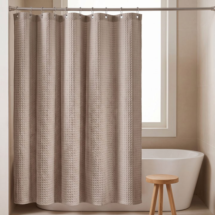 Fabric Shower Curtain – Waffle Weave in Taupe – fully drawn closed with a wooden stool beside it