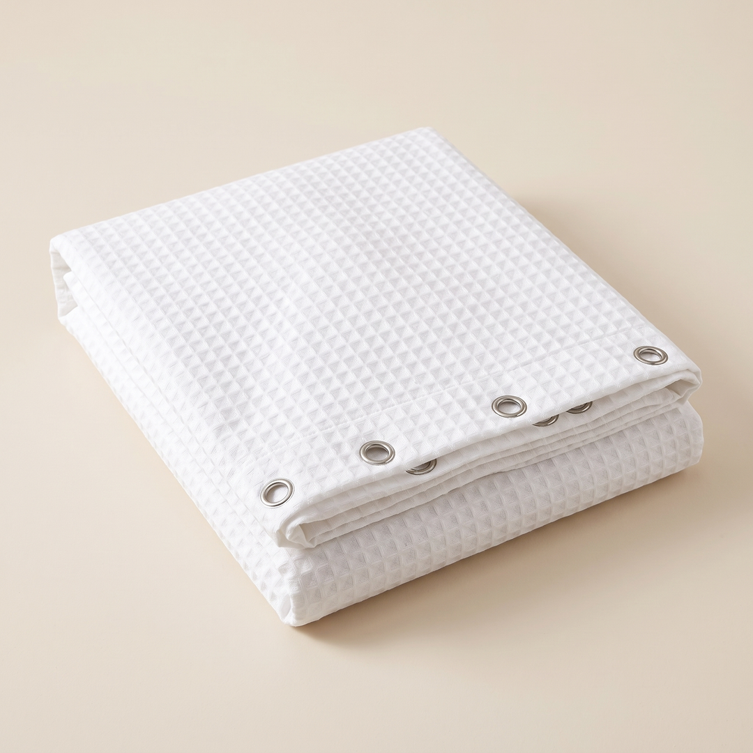Fabric Shower Curtain – Waffle Weave in White – folded neatly on a plain surface with metal grommets visible along the edge