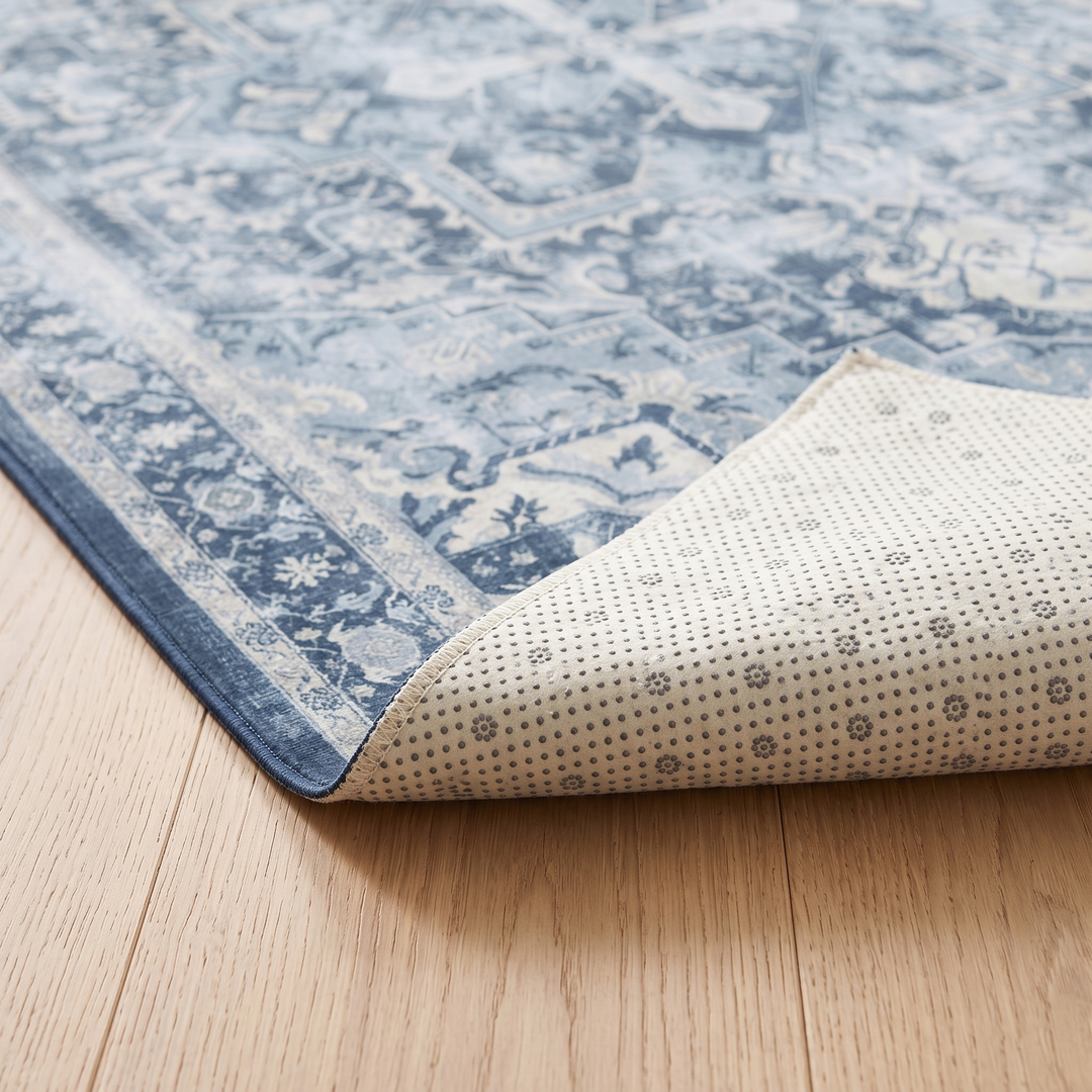 Washable Vintage Persian-Style Rug in Blue Medallion – corner folded back showing the dotted non-slip backing on wood floor