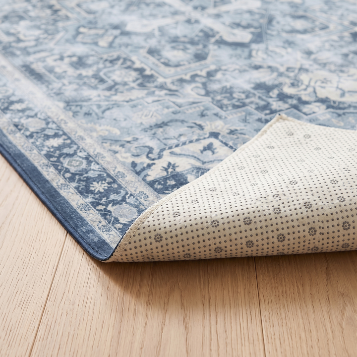 Washable Vintage Persian-Style Rug in Blue Medallion – corner folded back showing the dotted non-slip backing on wood floor