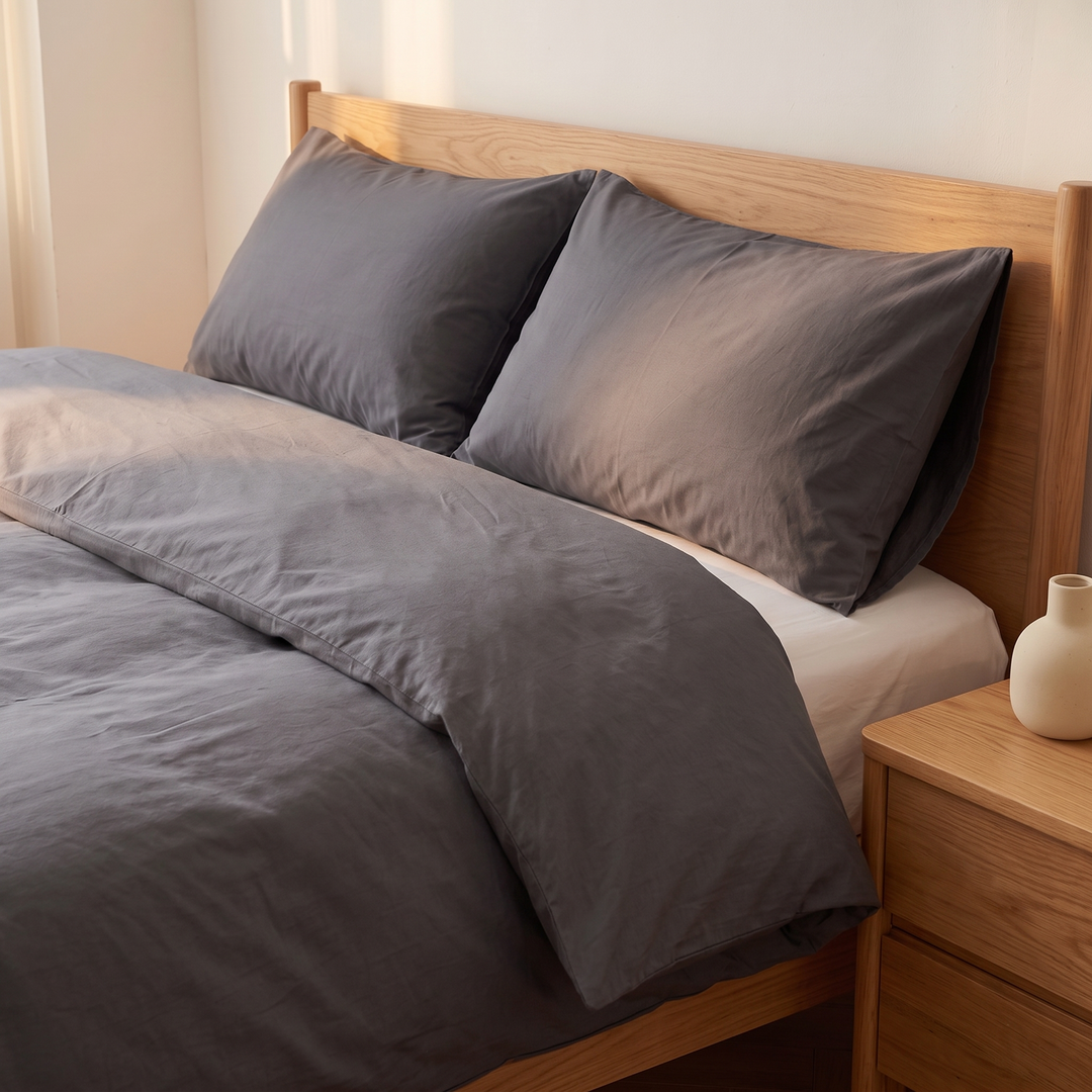 Washed Cotton Duvet Cover Set in Dark Gray – beside an oak nightstand with a small ceramic vase