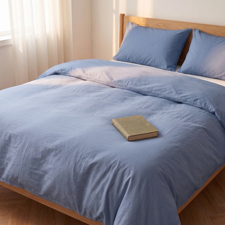 Washed Cotton Duvet Cover Set in Dusty Blue – closed book resting on the middle of the duvet