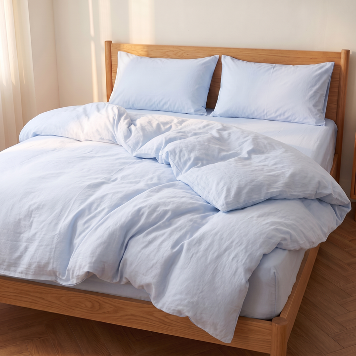 Washed Cotton Duvet Cover Set in Light Blue – wide view of rumpled loosely gathered duvet on unmade bed