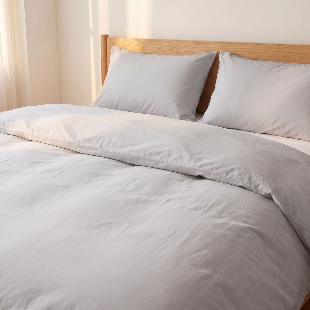 Washed Cotton Duvet Cover Set in Light Gray – two pillows against an oak headboard beside sheer curtains