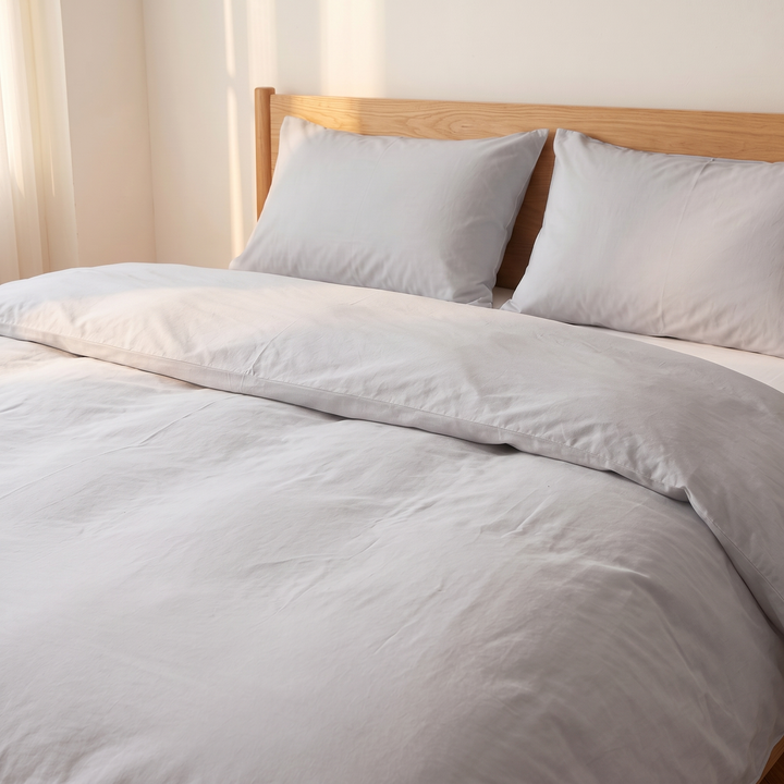 Washed Cotton Duvet Cover Set in Light Gray – two pillows against an oak headboard beside sheer curtains