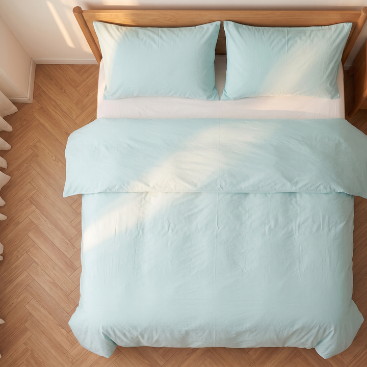 Washed Cotton Duvet Cover Set in Mint Green – top-down view of made bed on herringbone parquet floor