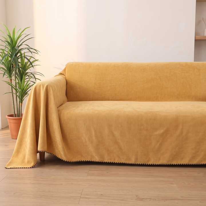 Water-Resistant Couch Cover – Throw Style in Yellow – front view on a sofa next to a potted plant