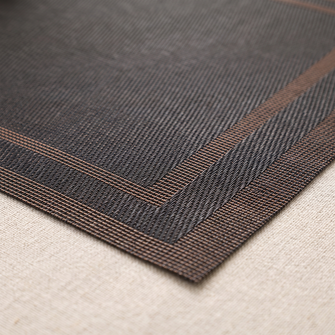 Woven Placemats – Wipe Clean in Black – Frame – close-up of one corner on a textured linen surface